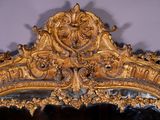 a mirror with a gold frame and a mirror with a lion head on it