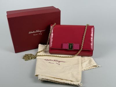 the red purse is next to a red box with a gold chain