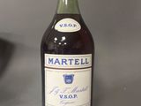 une bouteille de vin posée sur une table à côté d'un saladier