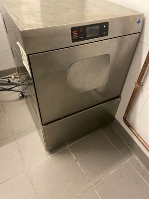 lave-vaisselle en acier inoxydable dans une cuisine professionnelle dotée d'un carrelage au sol