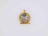 a close up of a pocket watch on a white surface