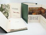 three open books on a white surface with a picture of a landscape in the pages