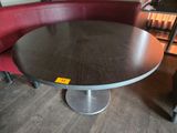 une table ronde avec un piètement en métal dans une pièce