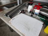 a table with a paper cutter and a spray bottle on it