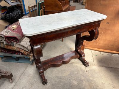 une table au plateau en marbre posée à même le sol