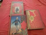 three books sitting on a red cloth covered table next to each other