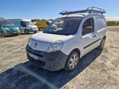 une petite camionnette blanche garée dans un parking