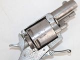 a silver revolver that is sitting on a white surface