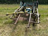 un tracteur qui se trouve dans l'herbe, avec un tuyau raccordé