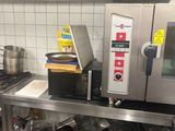 a kitchen with a stove, oven, sink, and other items on the counter