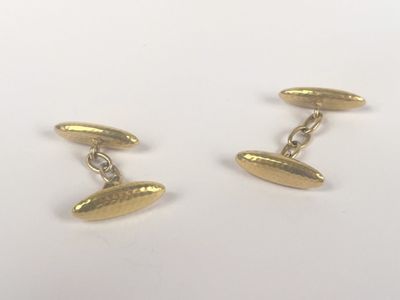 a pair of gold cufflinks on a white background