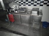 une cuisine équipée d'une cuisinière, d'un évier et d'un réfrigérateur