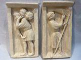 pair of stone reliefs of a man and a woman with a staff