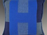 un coussin bleu et gris orné d'une croix