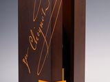 une image représentant une bouteille de vin dans un coffret en bois sur lequel figure une signature
