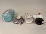 three vases and a candle holder on a table