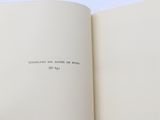 an open book with a hand holding a pen and writing on it