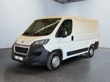 La camionnette blanche est garée dans une grande pièce, avec un panier au-dessus.