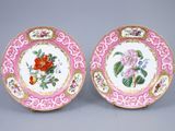 deux assiettes roses et blanches ornées de fleurs, posées sur un fond gris