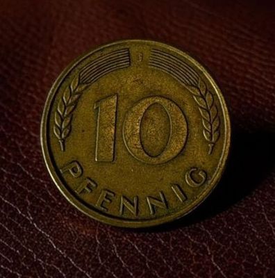 a close up of a ten cent coin on a brown leather surface