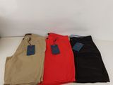 three pairs of men ' s pants sitting on a white surface