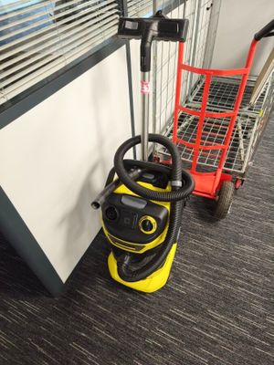 a vacuum cleaner that is on the floor next to a shopping cart