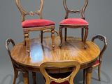 quatre chaises disposées autour d'une table sur laquelle est posé un coussin rouge