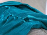 a close up of a teal colored dress on a mannequin