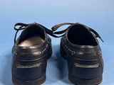 pair of black leather shoes with laces on them on a blue background