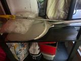 a metal spatula sitting on top of a shelf next to a bottle of water