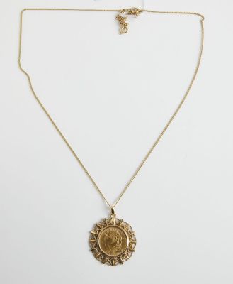 un collier en or avec une pièce de monnaie sur une chaîne
