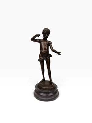 une statue en bronze représentant un garçon levant la main
