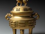 an image of a gold incense box with two lions on top