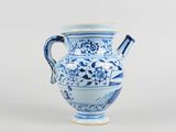 a blue and white vase with a handle on it