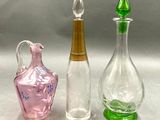 trois bouteilles en verre posées les unes à côté des autres sur une table