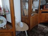 une petite table sur laquelle se trouve un vase, dans un coin de la pièce