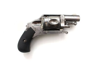 un revolver argenté avec une poignée noire sur une surface blanche