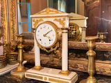 a clock that is sitting on a table in front of a mirror