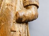 une statue en bois d'un homme avec un chapeau sur la tête
