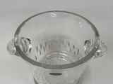 a clear glass vase with a handle on a white table