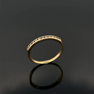 une bague en or avec des diamants sur une surface noire