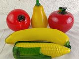 a banana, corn, tomato, and pepper on the table