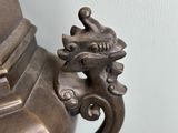 a silver vase with a dragon on it on a table