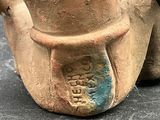 a vase with a face on it sitting on a table