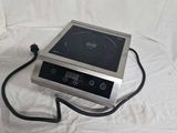 une photo d'une petite cuisinière électrique posée sur un drap blanc
