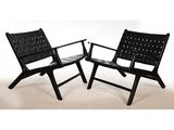 une paire de fauteuils de salon en cuir noir avec des coussins en cuir noir