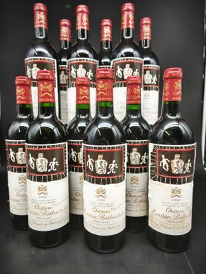 six bouteilles de vin rouge sont alignées sur une table noire