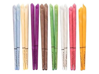 Plusieurs stylos de différentes couleurs sont alignés sur une surface blanche.