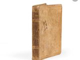 an old book sitting on top of a table next to a white background