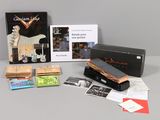 une photo d'une collection d'objets liés à la musique, comprenant notamment une guitare, une cassette, un CD et d'autres objets